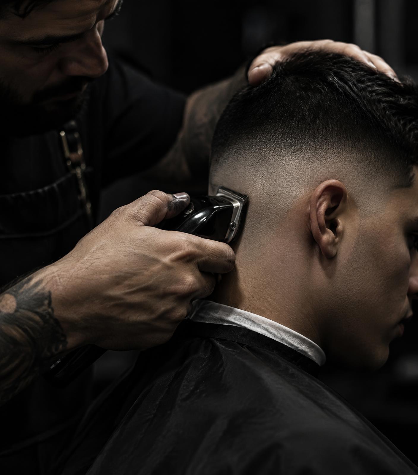 Barber cutting a sharp skin fade with clippers